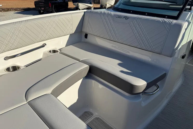 Slide: The Image of 2026 Sea Ray SDX 230 boat interior with cushioned seating and cup holders. - 12