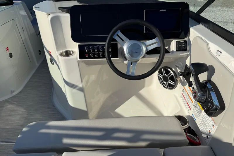 Slide: The Image of 2026 Sea Ray SDX 230 boat cockpit with steering wheel and control panel. - 14