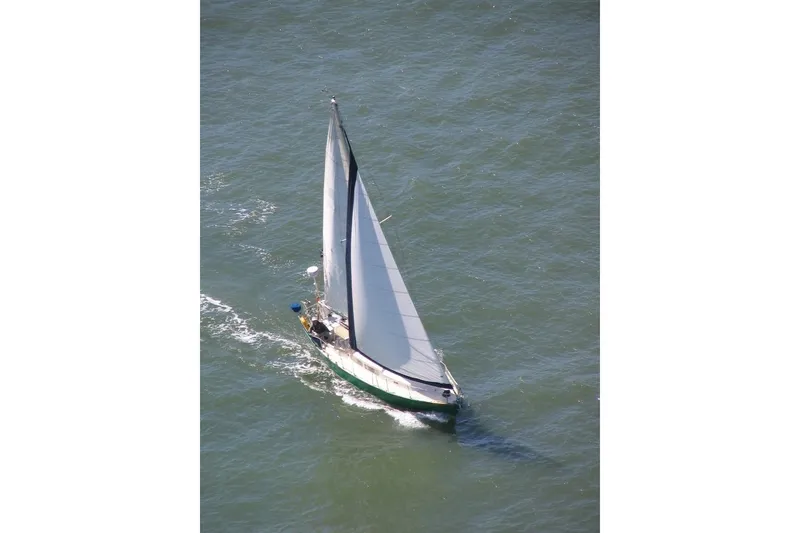 The Image of Aerial view of a 1968 Spencer 35 sailboat navigating through open water. - 0