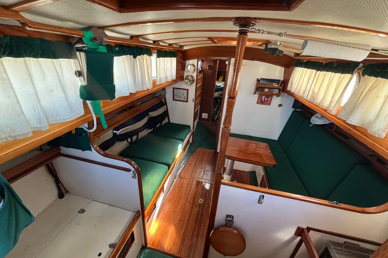 Slide: The Image of Interior of a 1968 Spencer 35 sailboat with green seating and wooden accents. - 11