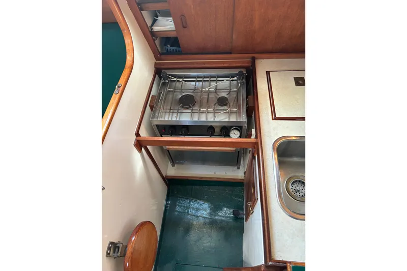 Slide: The Image of Compact kitchen area in a 1968 Spencer 35 boat, featuring a stove and sink. - 13