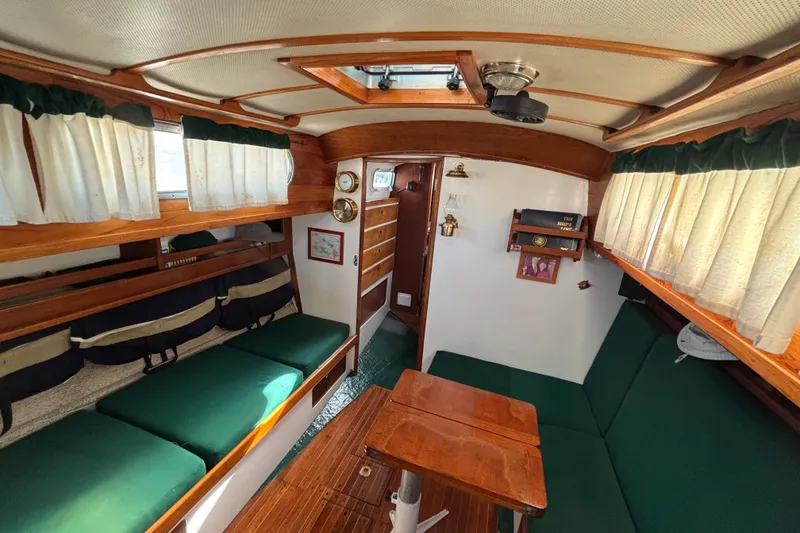 Slide: The Image of Interior of a 1968 Spencer 35 sailboat with wooden furnishings and green seating. - 14