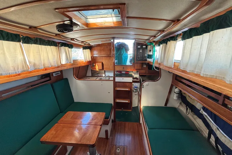 Slide: The Image of Interior of a 1968 Spencer 35 sailboat with green seating and wooden accents. - 19