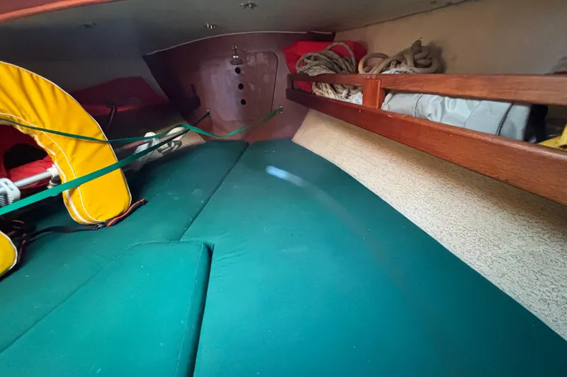 Slide: The Image of Interior of a 1968 Spencer 35 sailboat with green cushions and storage shelves. - 24
