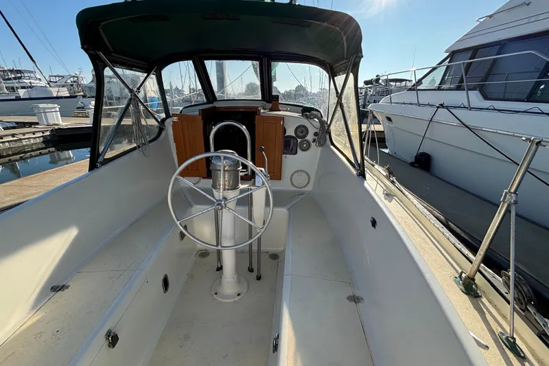 Slide: The Image of 1968 Spencer 35 sailboat cockpit with steering wheel, docked at marina. - 6