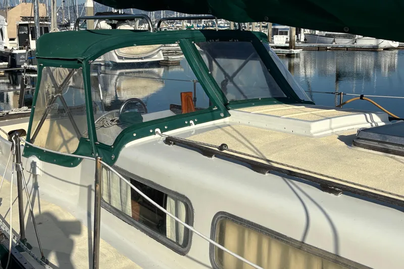Slide: The Image of 1968 Spencer 35 sailboat with green canopy docked in marina. - 7