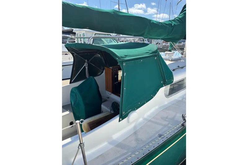 Slide: The Image of 1968 Spencer 35 sailboat with green canvas cover in marina setting. - 9