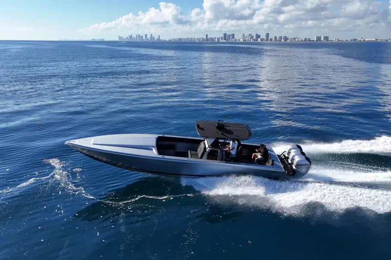 The Image of 2006 Lazer 40 speedboat cruising on open water with city skyline in background. - 0