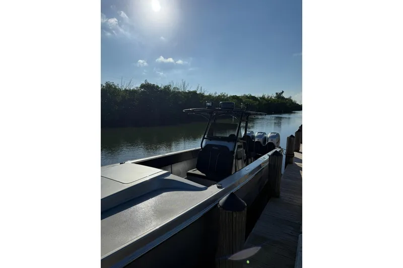 Slide: The Image of 2006 Lazer 40 boat docked by a serene river under a bright sky. - 13