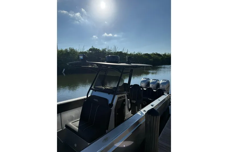 Slide: The Image of 2006 Lazer 40 boat docked on a sunny day, featuring multiple outboard engines. - 14