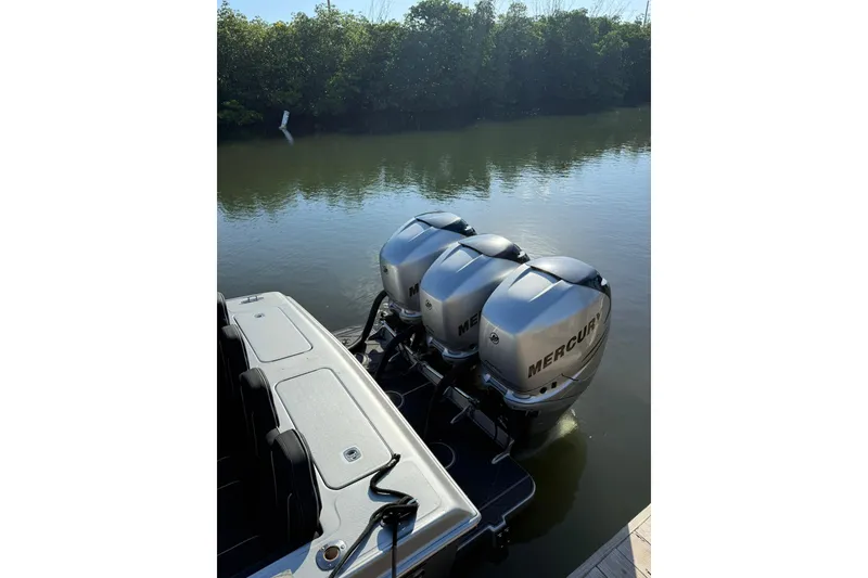Slide: The Image of 2006 Lazer 40 boat with triple Mercury outboard engines on a calm river. - 18