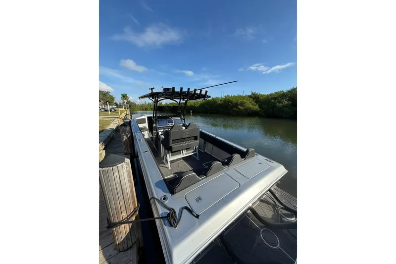 Slide: The Image of 2006 Lazer 40 boat docked by a serene river under a clear blue sky. - 22