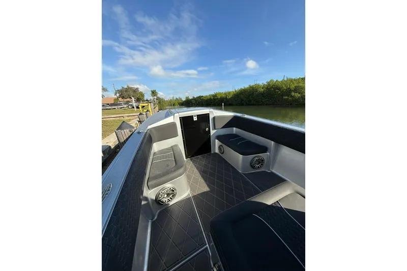 Slide: The Image of 2006 Lazer 40 boat interior with seating and speakers, docked by a scenic river. - 39
