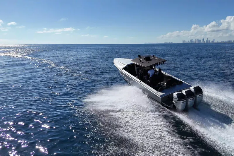 Slide: The Image of High-speed Lazer 40 boat cruising on open sea, 2006 model, with city skyline in background. - 4