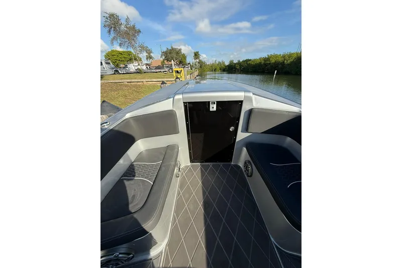 Slide: The Image of 2006 Lazer 40 boat interior with seating, docked by a scenic canal. - 40