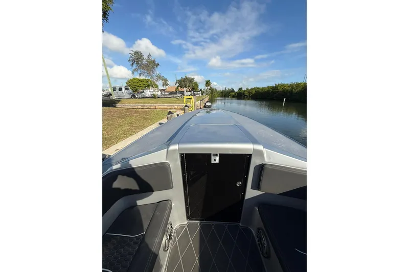 Slide: The Image of 2006 Lazer 40 boat docked by a serene canal under a clear blue sky. - 45