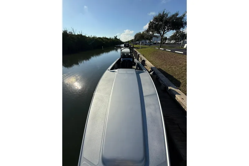 Slide: The Image of 2006 Lazer 40 boat docked by a calm river under a clear blue sky. - 48