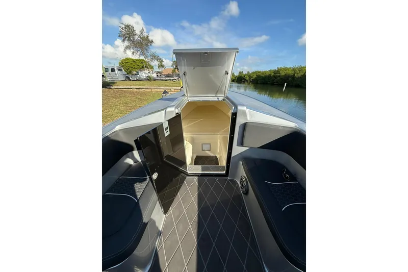 Slide: The Image of 2006 Lazer 40 boat interior with open cabin door, docked by a scenic waterway. - 50