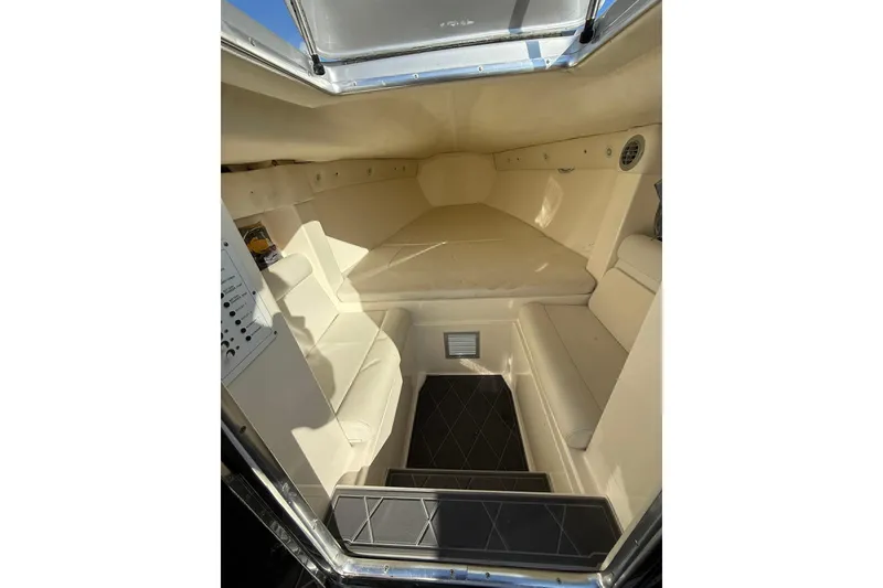 Slide: The Image of Interior cabin of a 2006 Lazer 40 boat, featuring beige seating and compact design. - 51