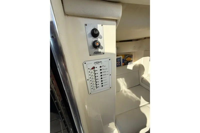 Slide: The Image of Control panel inside 2006 Lazer 40 boat, featuring switches and seating area. - 52