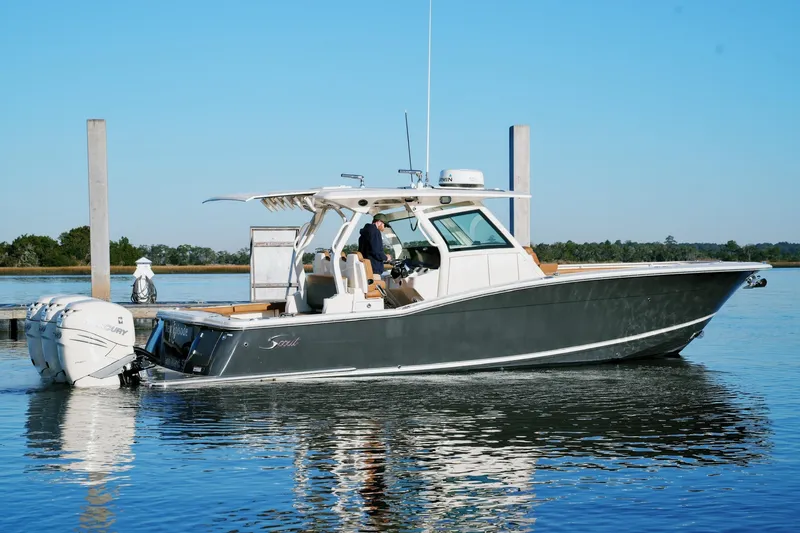 The Image of 2021 Scout 355 LXF boat on calm water, featuring twin Mercury engines. - 0