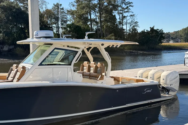 Slide: The Image of 2021 Scout 355 LXF boat docked by a scenic riverside with trees. - 10
