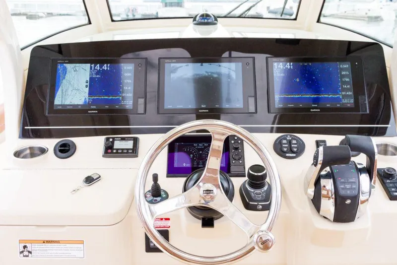 Slide: The Image of Manufacturer Provided Image: 2021 Scout 355 LXF boat dashboard with navigation screens and steering wheel. - 100