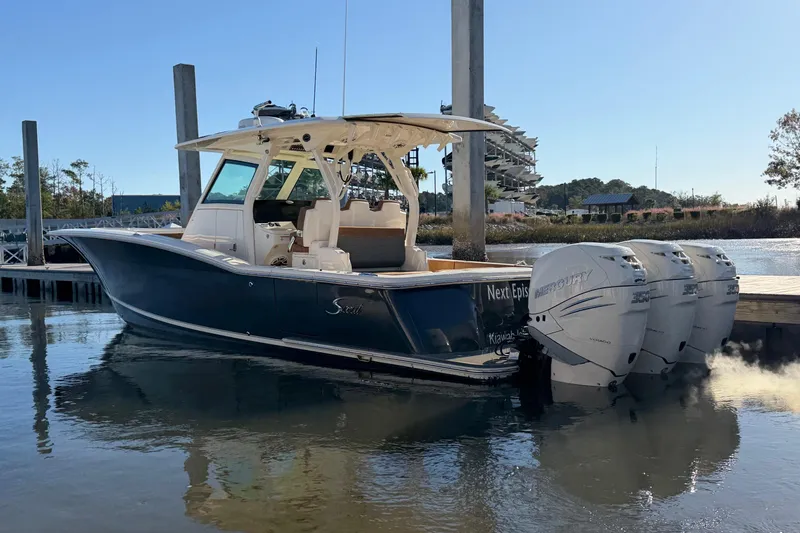 Slide: The Image of 2021 Scout 355 LXF boat docked with triple Mercury engines. - 11