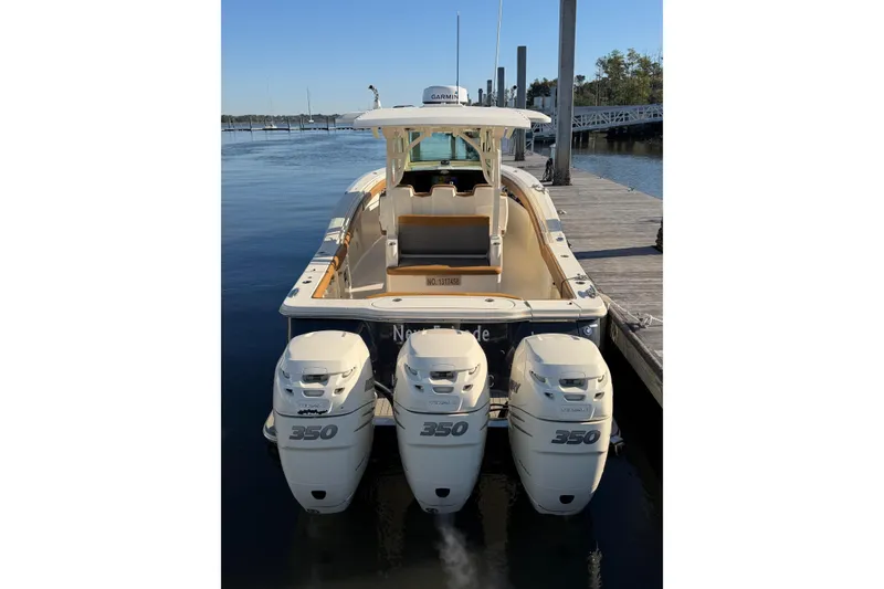 Slide: The Image of 2021 Scout 355 LXF boat with triple 350 engines docked at marina. - 12