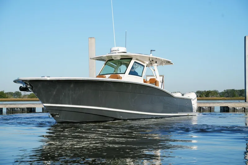 Slide: The Image of 2021 Scout 355 LXF boat on calm water, showcasing sleek design and luxury features. - 2