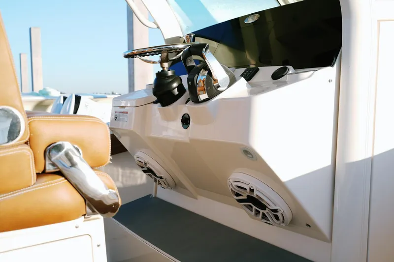 Slide: The Image of 2021 Scout 355 LXF boat helm with steering wheel and controls. - 21