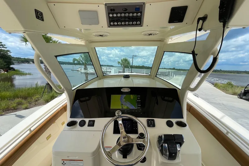Slide: The Image of 2021 Scout 355 LXF boat helm with navigation system and scenic water view. - 24