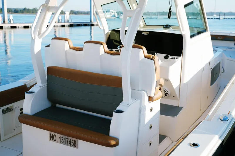 Slide: The Image of 2021 Scout 355 LXF boat interior with seating, docked by the water. - 26