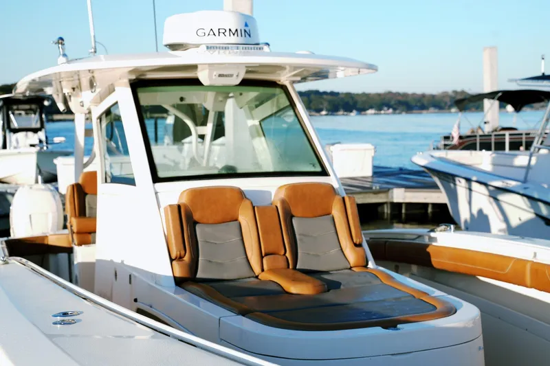 Slide: The Image of 2021 Scout 355 LXF boat with Garmin equipment, docked by the water. - 29