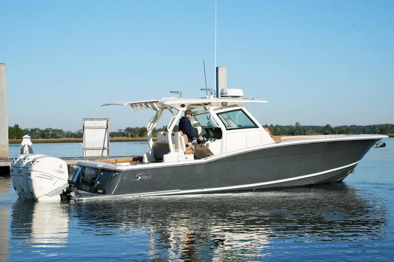 Slide: The Image of 2021 Scout 355 LXF boat on calm water, featuring sleek design and twin Mercury engines. - 3