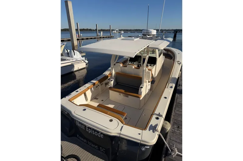 Slide: The Image of 2021 Scout 355 LXF boat docked at marina, featuring spacious deck and modern design. - 31