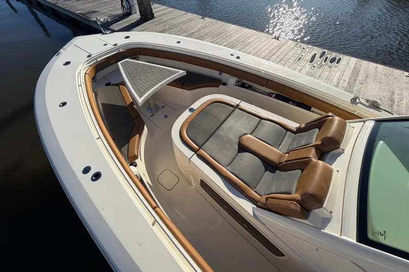 Slide: The Image of 2021 Scout 355 LXF boat with luxurious seating and sleek design at a dock. - 32