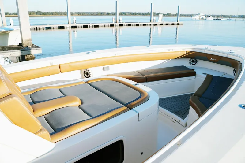 Slide: The Image of 2021 Scout 355 LXF boat interior with luxurious seating at a marina. - 33