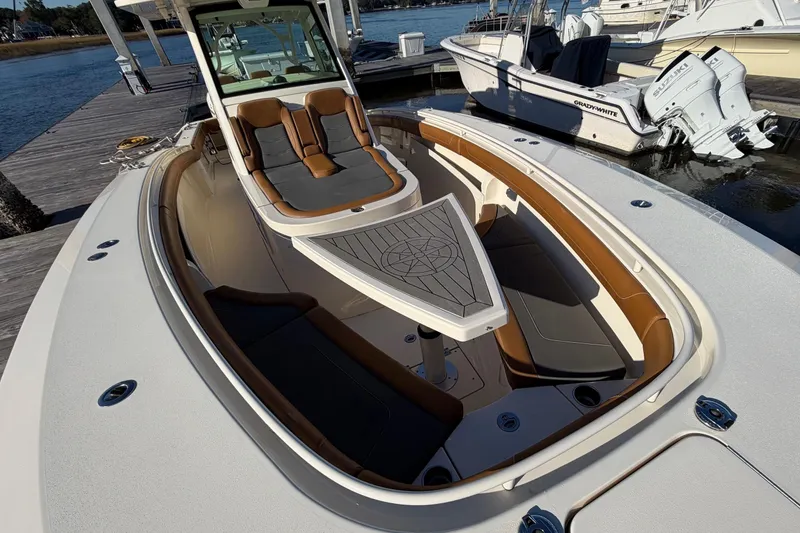 Slide: The Image of 2021 Scout 355 LXF boat with luxurious seating and sleek design at a dock. - 37