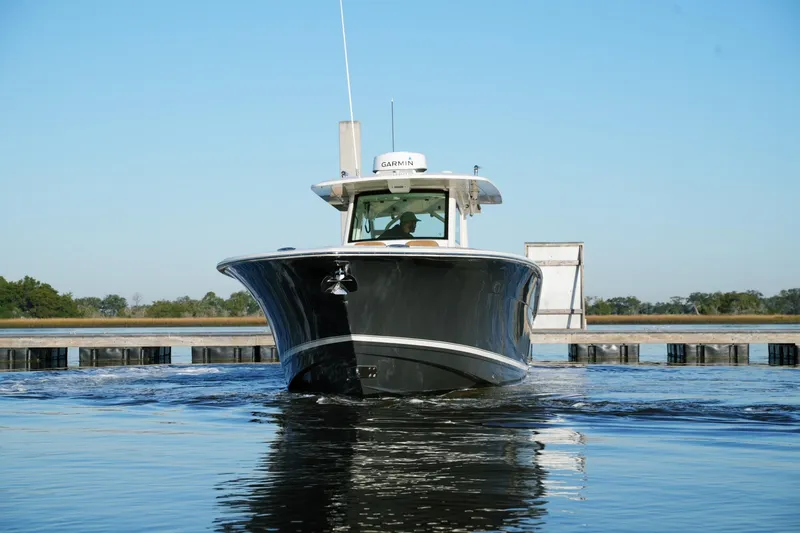 Slide: The Image of 2021 Scout 355 LXF boat on calm water, front view, clear sky background. - 5