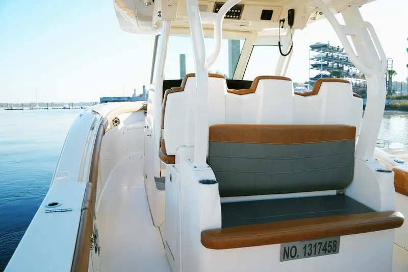 Slide: The Image of 2021 Scout 355 LXF boat interior with seating, docked by calm waters. - 53