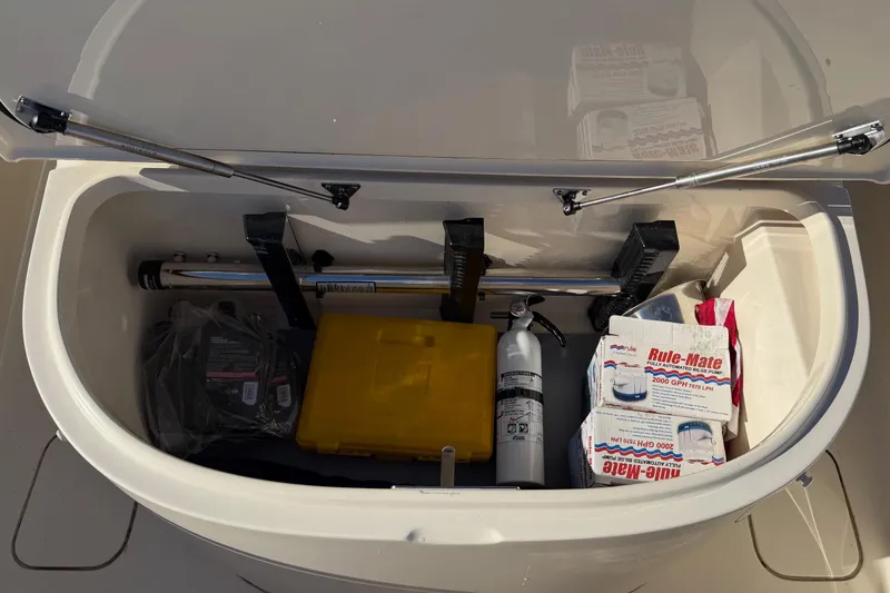 Slide: The Image of Storage compartment of 2021 Scout 355 LXF boat with safety equipment and supplies. - 55