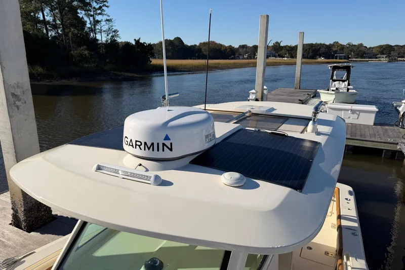 Slide: The Image of 2021 Scout 355 LXF boat with Garmin radar docked by a scenic river. - 57