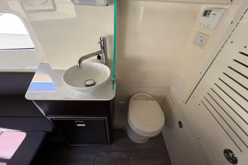 Slide: The Image of 2021 Scout 355 LXF boat bathroom with sink, toilet, and modern fixtures. - 62