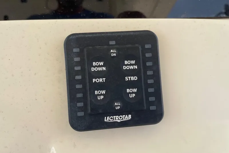Slide: The Image of Control panel on a 2021 Scout 355 LXF boat, featuring Lectrotab trim tab controls. - 67
