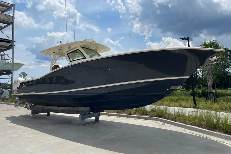 Slide: The Image of 2021 Scout 355 LXF boat displayed outdoors under a cloudy sky. - 8