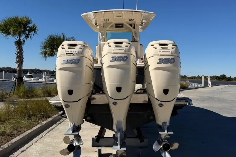 Slide: The Image of 2021 Scout 355 LXF boat with triple 350 Verado engines at a marina. - 80