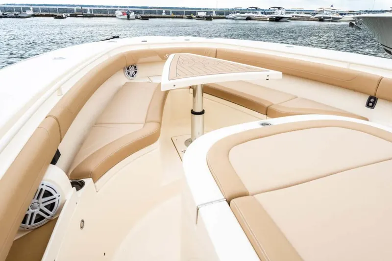 Slide: The Image of Manufacturer Provided Image: 2021 Scout 355 LXF boat with tan seating and a triangular table on the deck. - 93