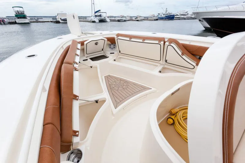Slide: The Image of Manufacturer Provided Image: 2021 Scout 355 LXF boat interior with tan seating at marina. - 94