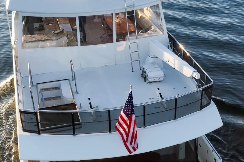 Slide: The Image of 2014 Ocean Alexander 85 Cockpit Motoryacht cruising with American flag on deck. - 32